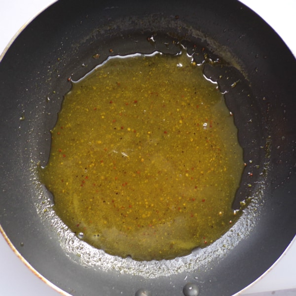 A black frying pan with a honey mustard sauce made with stone ground mustard