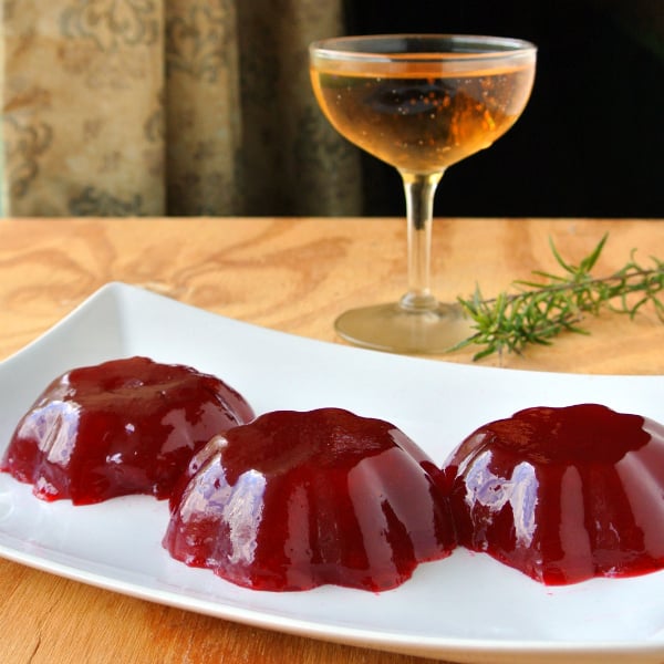 Ginger Ale Cranberry Sauce on a plate with ginger ale in a cup in the background