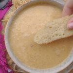 A bowl of Cream of Turnip soup with a piece of bread over it.