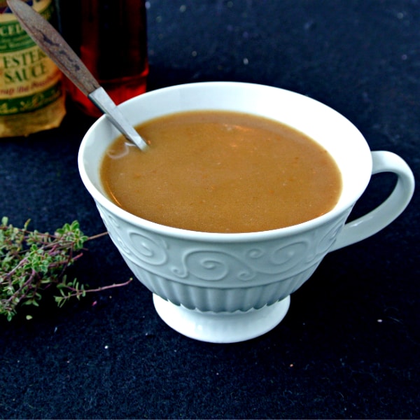 Maple-Worcestershire Gravy in a white cup on a black surface