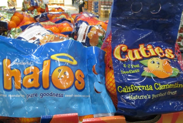 A bag of Halos mandarins next to a bag of Cuties California clementines.