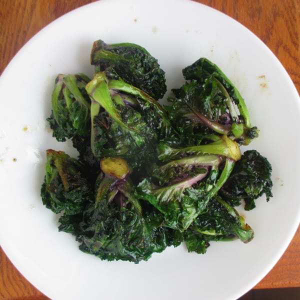 Kalettes that have been sauteed and are on a white plate