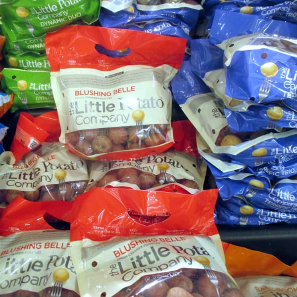 Bags of Little Potato Company at the grocery store. There different types are shown including Blushing belle, Dynamic Duo, and Terrific Trio