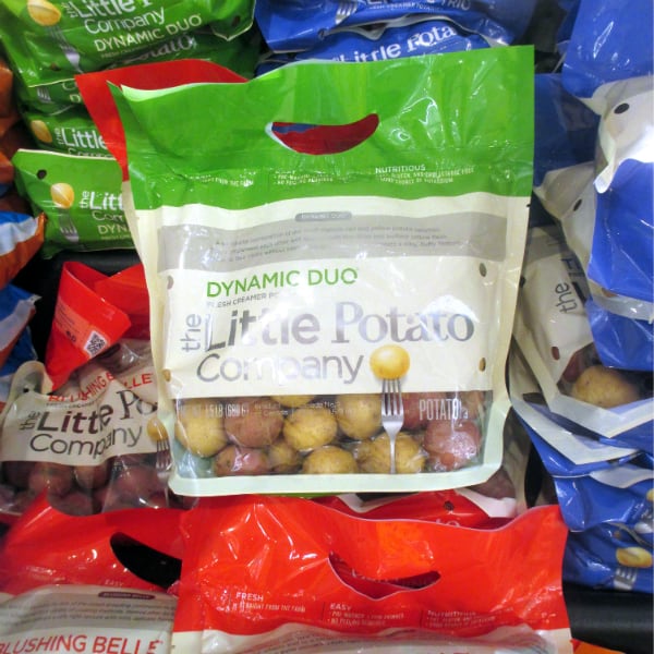 Little Potato Company Dynamic Duo bag is centered on top of more bags of different varieties of potatoes from Little Potato company.