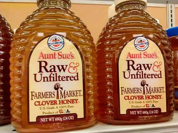 Containers of Aunt Sue's Raw & Unfiltered Clover Honey at the store