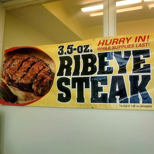 A sign at a Dollar Tree advertises a 3.5 oz ribeye steak for 