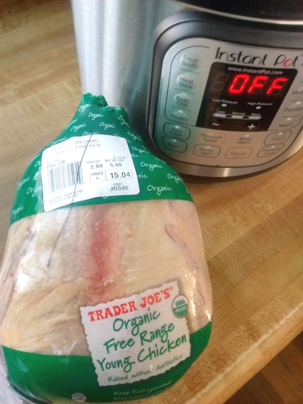 A whole Trader Joe's Organic Free Range turkey sitting on a countertop in front of the Instant Pot.
