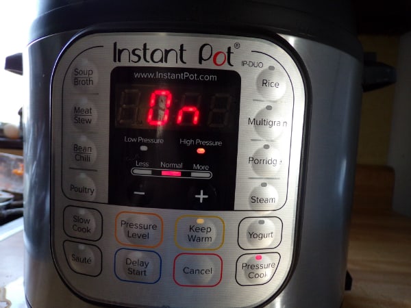 The Instant Pot on a counter. It reads on and high pressure.