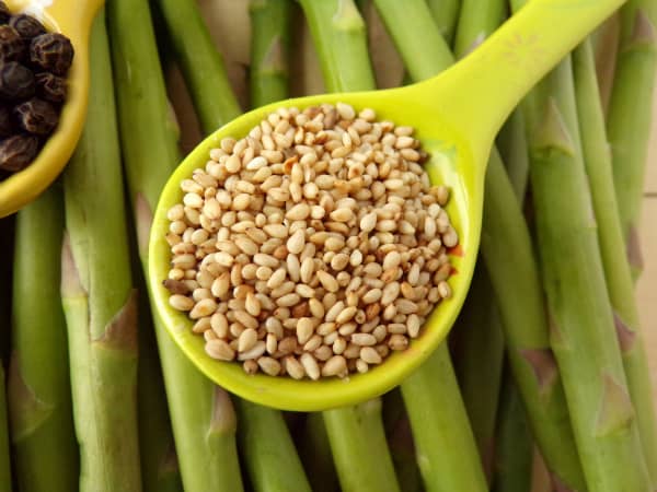 Spoon of sesame seeds on asparagus