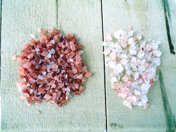 One pile of dark red and pink Himalayan salt and one pile of white opaque and link pink Himalayan salt.