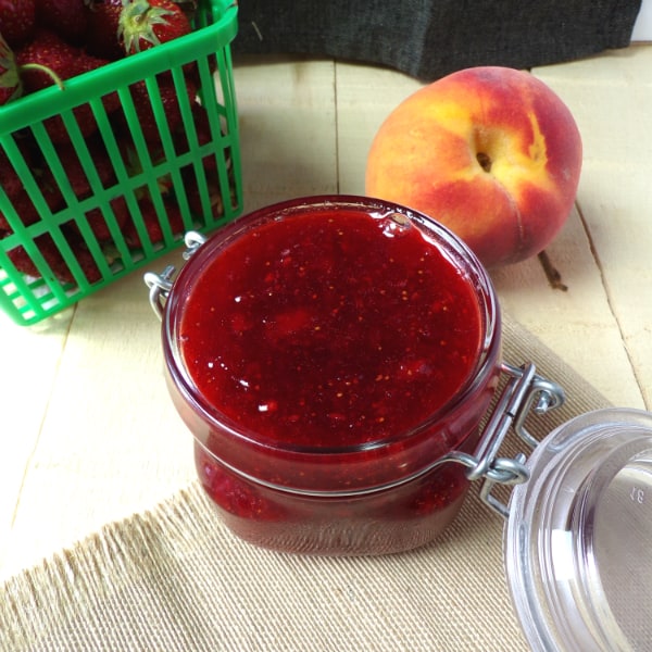 A Ball jar filled with strawberry-peach jam.