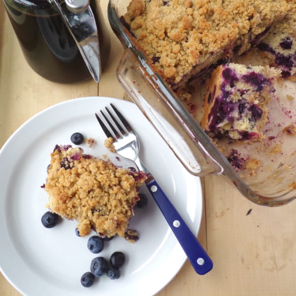 A picture of Maple Blueberry Buckle with a slice sitting on a white plate