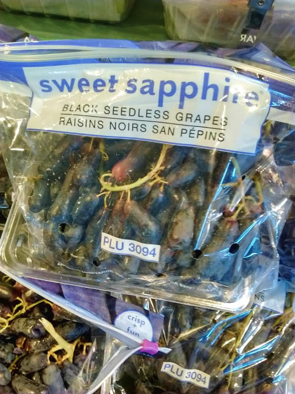 A bag of Sweet Sapphire black seedless grapes at the grocery store.