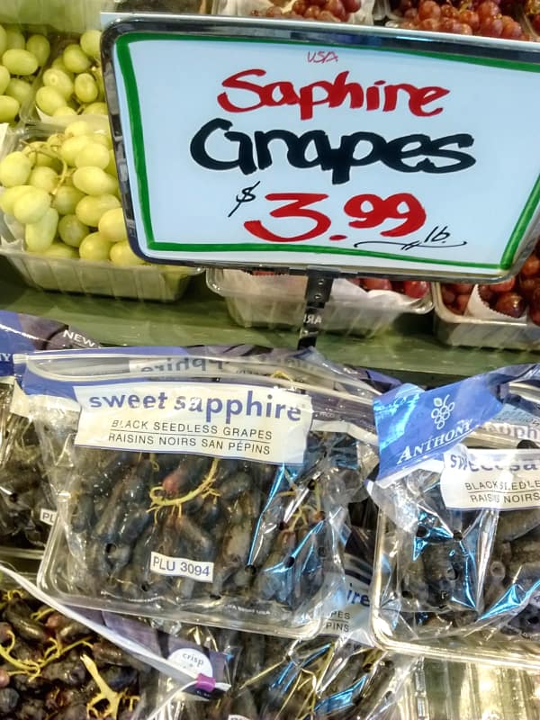A display of Sweet Sapphire grapes at a grocery store. Sapphire is misspelled on the sign.
