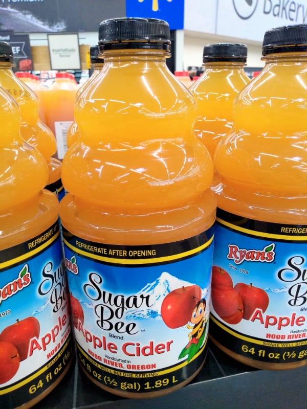 Containers of Ryan's Brand Sugar Bee Apple Cider Blend at a Walmart store.