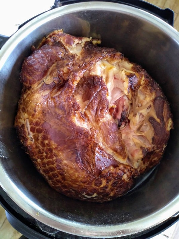 A finished ham inside the Instant Pot with the lid off.