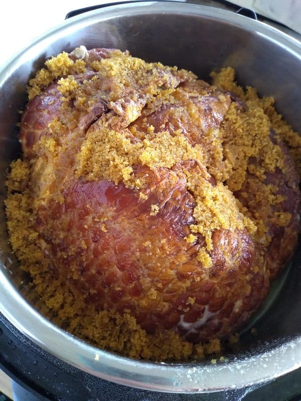 Brown sugar on top of a ham inside an Instant Pot with the lid off.