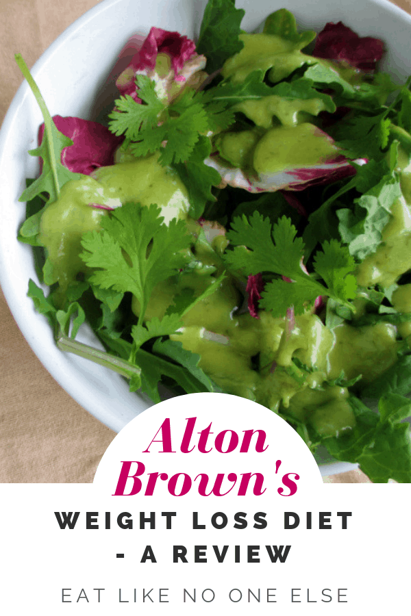 A mixed green salad with avocado dressing in a bowl with the words "Alton Brown's Weight Loss Diet - A Review" underneath.