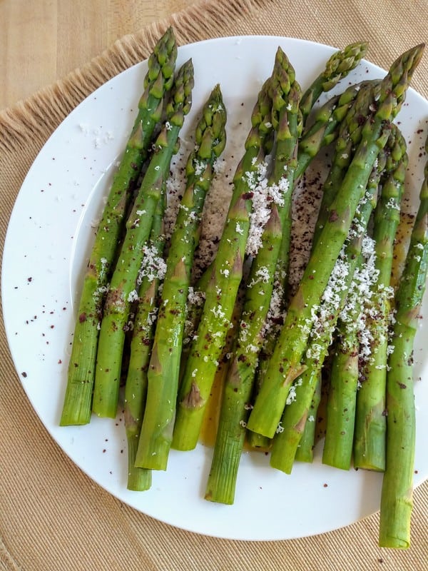 Plate of asparagus with romano cheese and sumac on top