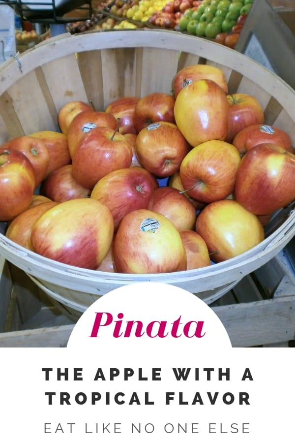 Pinata Apples in a bushel basket at a grocery store.