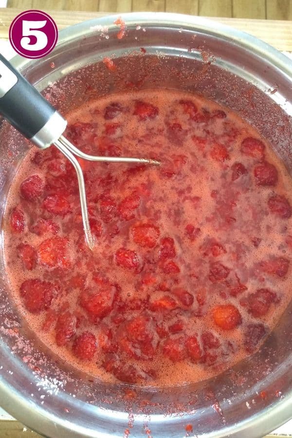 Smash strawberries with a potato masher