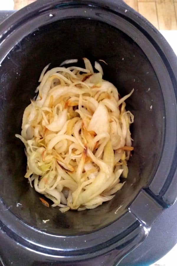Onions beginning to caramelize in a slow cooker