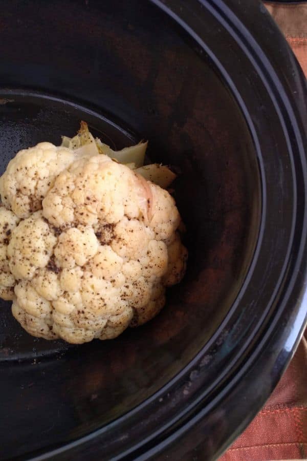 Whole head of cauliflower cooked in a slow cooker
