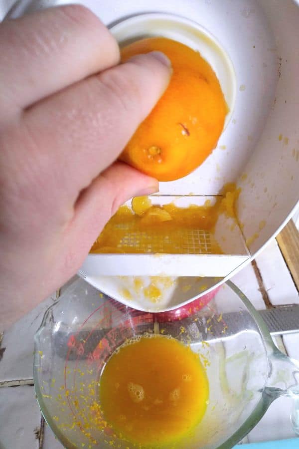 KitchenAid Citrus Juicing Attachment being used to juice oranges into a glass measuring cup