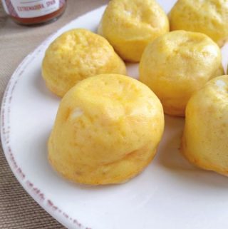 Egg bites on a white plate that contain manchego cheese and smoked paprika.