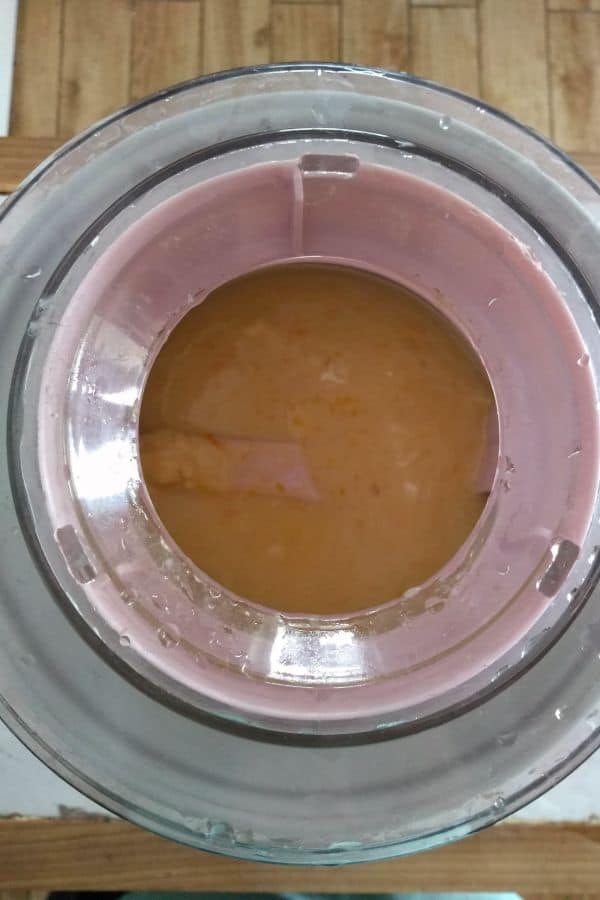 Starting to churn orange sherbet in an ice cream maker