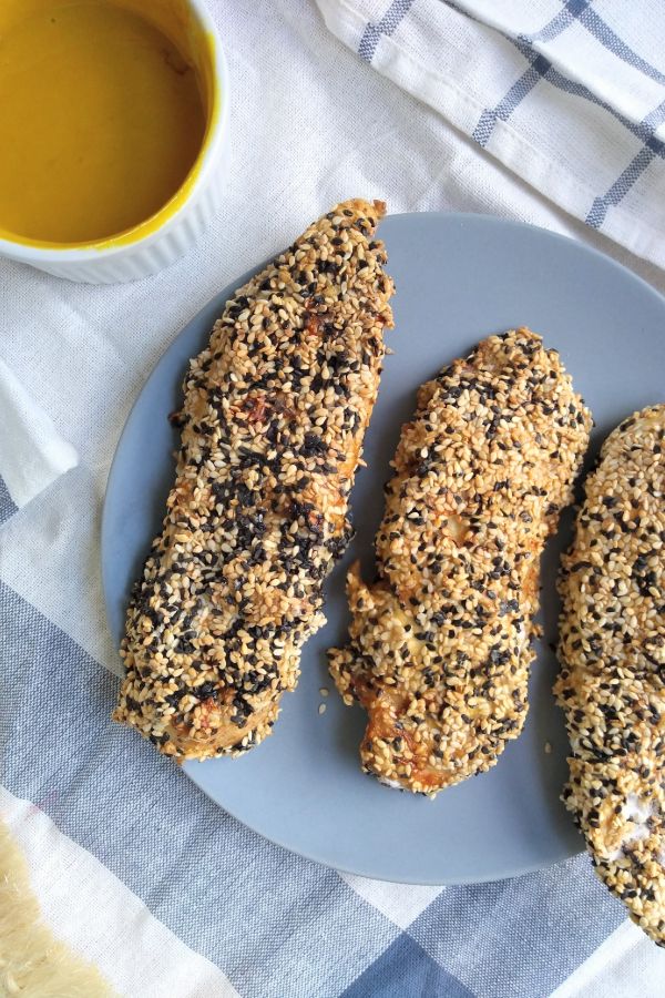 Picture of sesame encrusted chicken tenders on a blue plate. 