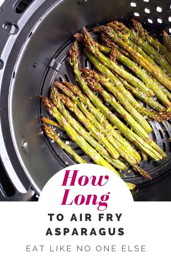 Asparagus that is done sitting inside of an air fryer basket