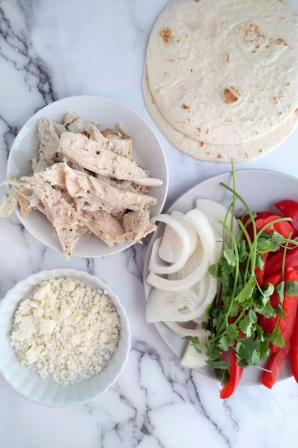 All the ingredients for turkey fajitas - leftover turkey, peppers, Cotija cheese, onions, cilantro, and flour tortillas