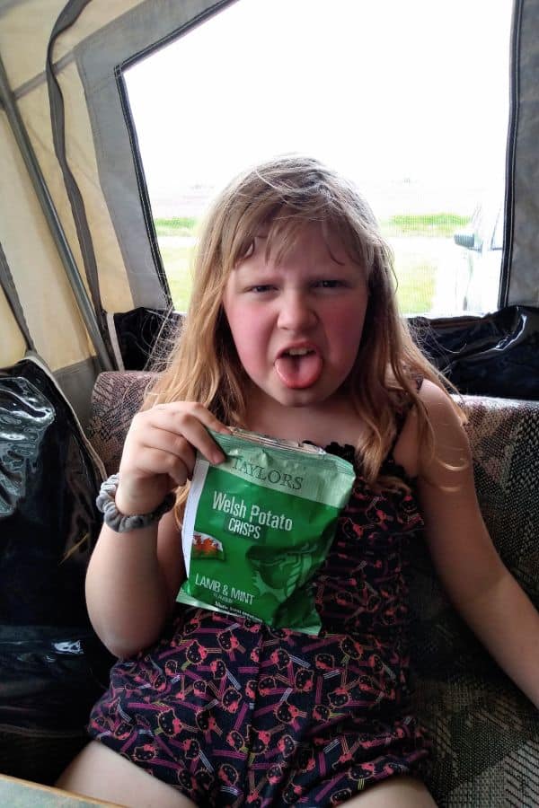 The author's daughter holding up a bag of Taylors Welsh Lamb and Mint chips. She is making a yucky face.