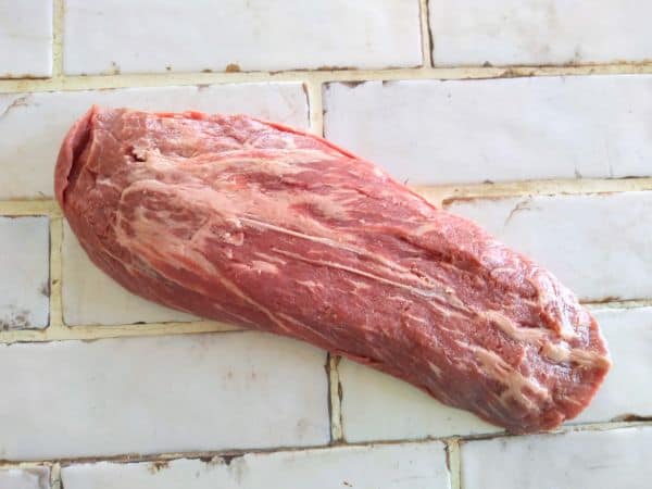 A raw flat iron steak sitting on a counter top