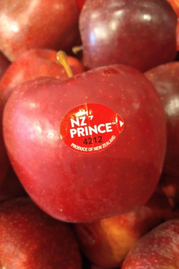 A display of red NZ prince apples with the camera focused on a single apple and it's PLU sticker.