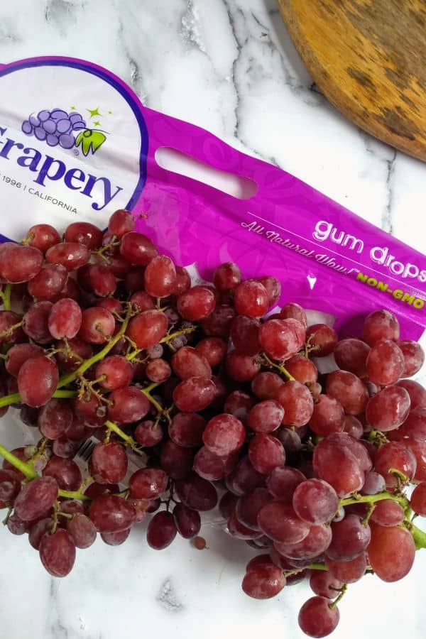 Candy Snaps Gum Drops grapes are sitting on a counter in bunches with the bag in the background