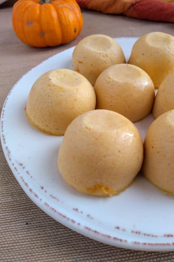 Pumpkin Egg Bites on a white plate with a brown pattern on the edge.