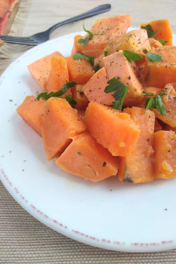 A white plate of cubed cooked sweet potatoes