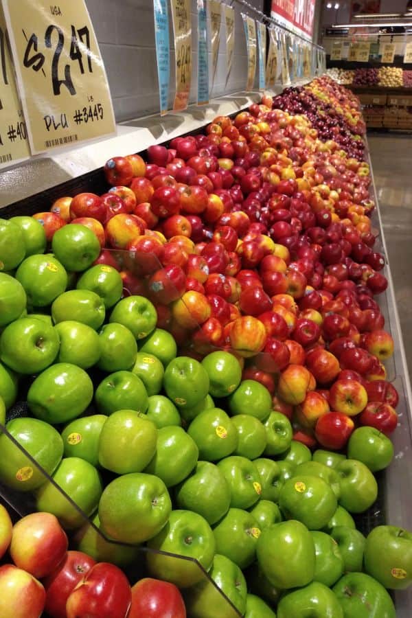 A display of several different types of apples of various colors and shapes. 