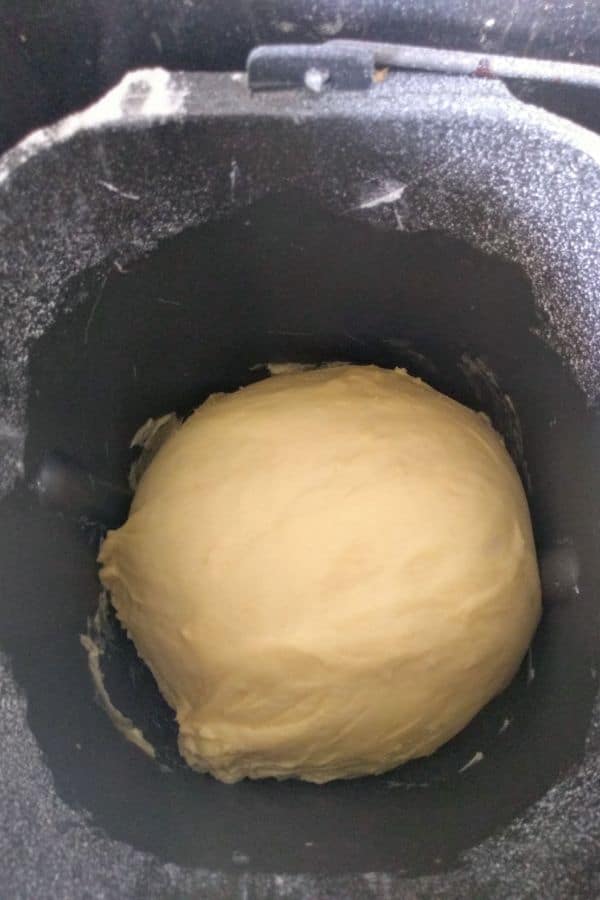 A dough ball sitting inside of a bread machine