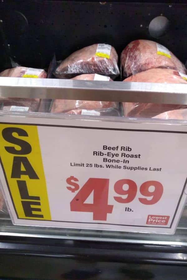 A sale sign for rib eye roast bone-in for $4.99/lb. While supplies last.