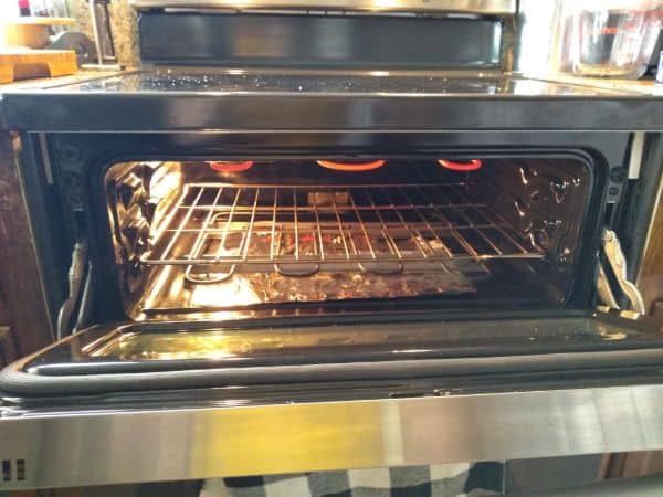 The upper part of an oven is shown with the oven door open and the broiler turned on.