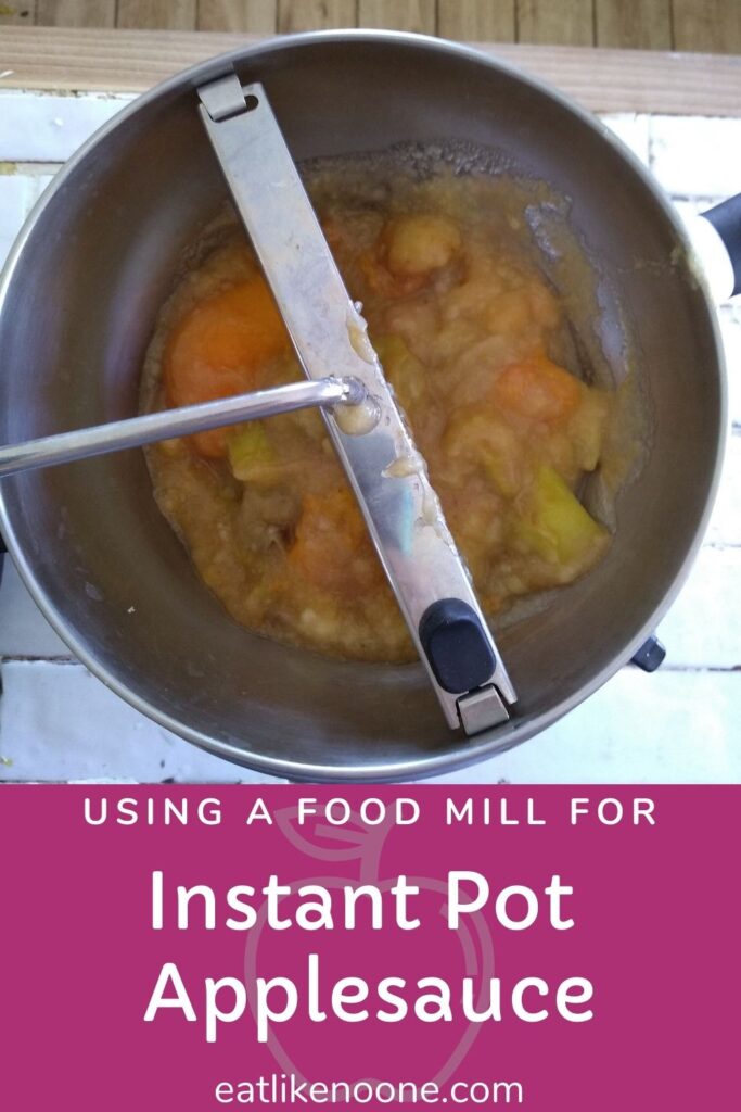 Applesauce inside a food mill sitting on a white tiled countertop with the words "Using a Food Mill for Instant Pot Applesauce"