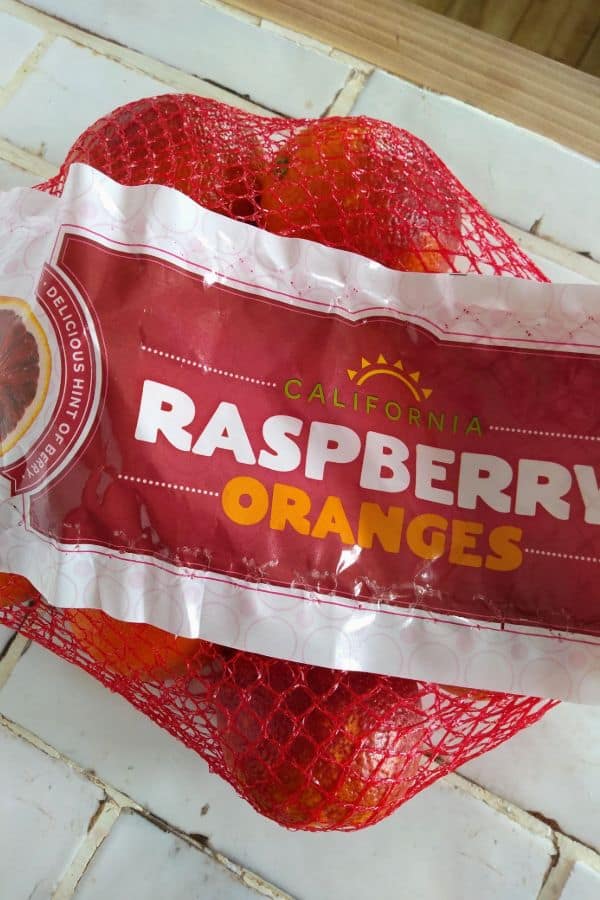 A bag of raspberry oranges sitting on a white counter.