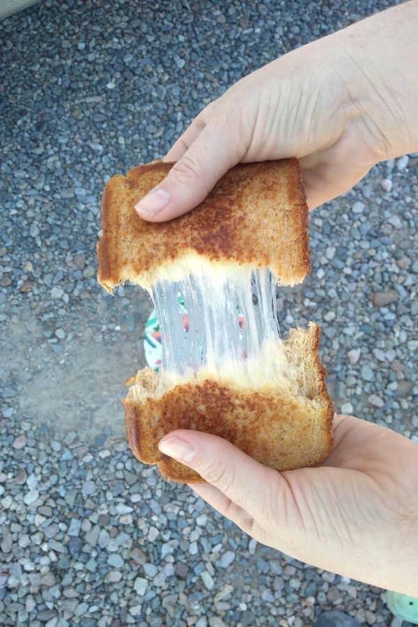 A grilled Blarney castle cheese sandwich being pulled apart, showing the melted cheese.