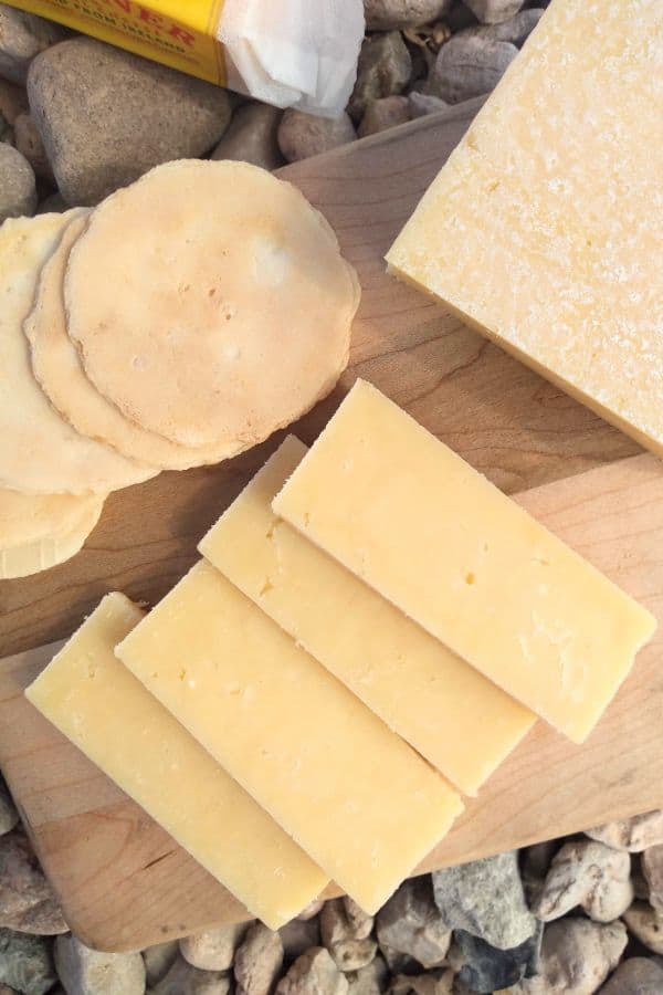 A close up showing the texture of the Dubliner cheese. It's appearance is similar to cheddar. You can see some white crystals on the biggest piece of cheese.