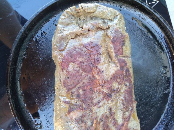A seared flat iron steak on top of a cast iron skillet