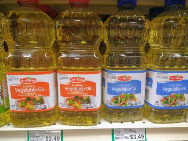 A grocery store shelf with bottles of Our Family 1005 pure vegetable oil (on the right) and Blended vegetable oil (on the left).
