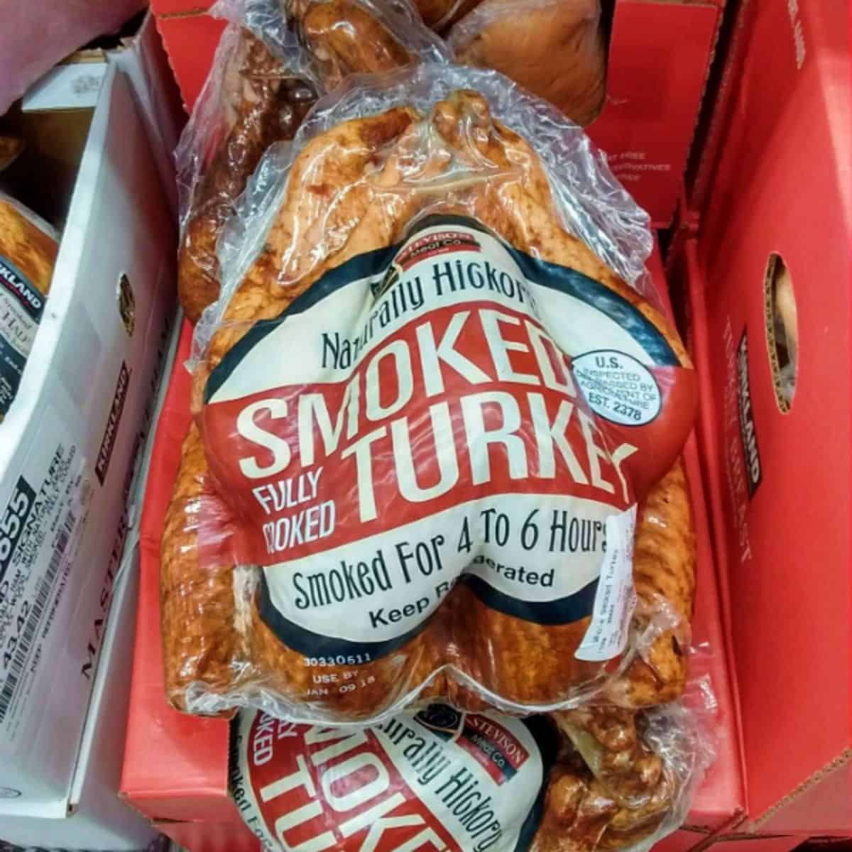 A display of Naturally Hickory Smoked turkey from Costco in clear plastic with the type of turkey listed on the front. 